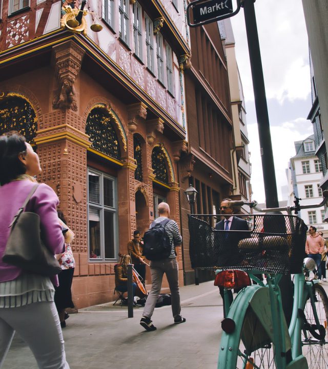 city, street, building, town, outdoors, sidewalk, bicycle, people, walking, bicycle, bicycle, people, people, walking, walking, walking, walking, walking
